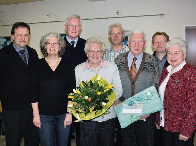 Foto: Kerstin Wessel Ferdinand Mönning und seine Frau freuen sich im Kreis des Vorstands im Kreis des Vorstands über Blumen und ein Präsent der Heimatfreunde Bad Westernkotten.
